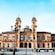 A historic building with 2 domed towers, arched windows and ornate architectural details